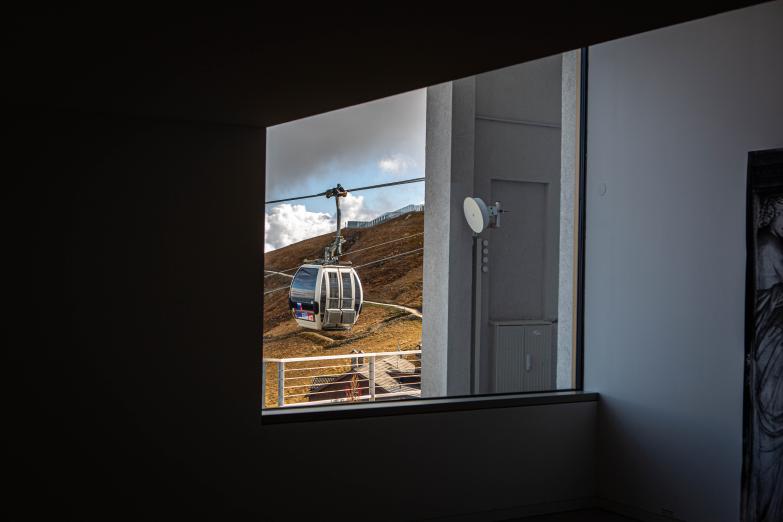 Kronplatz | Vorbeifahrende Gondel der Seilbahn durch ein Fenster im Lumen Museum